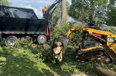 Heavy-duty CAT equipment and grapple truck removing large downed tree limbs in Augusta GA